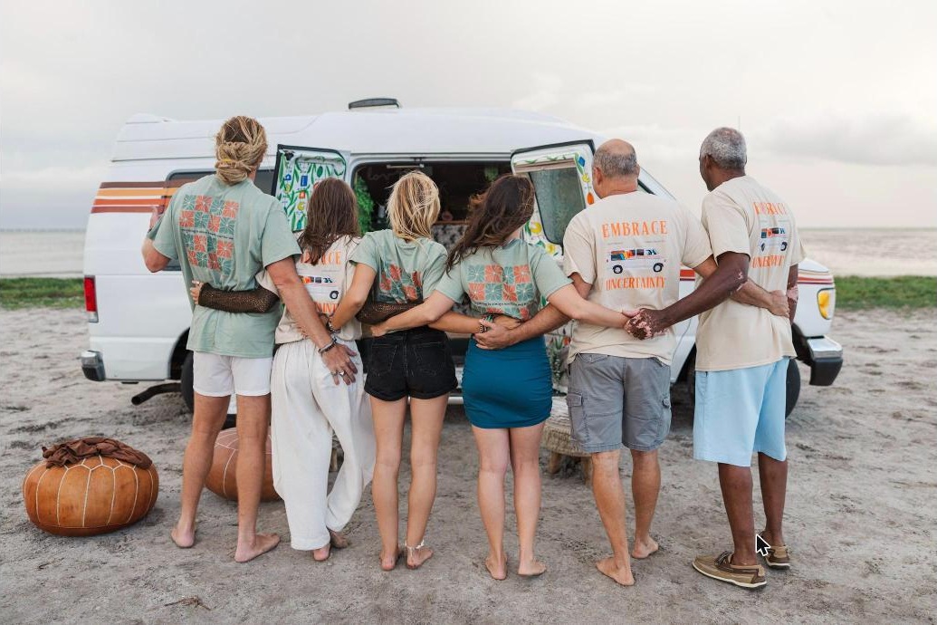 Florida Van Life Co. crew wearing the Embrace Uncertainty and mosaic tee designs in front of a camper van