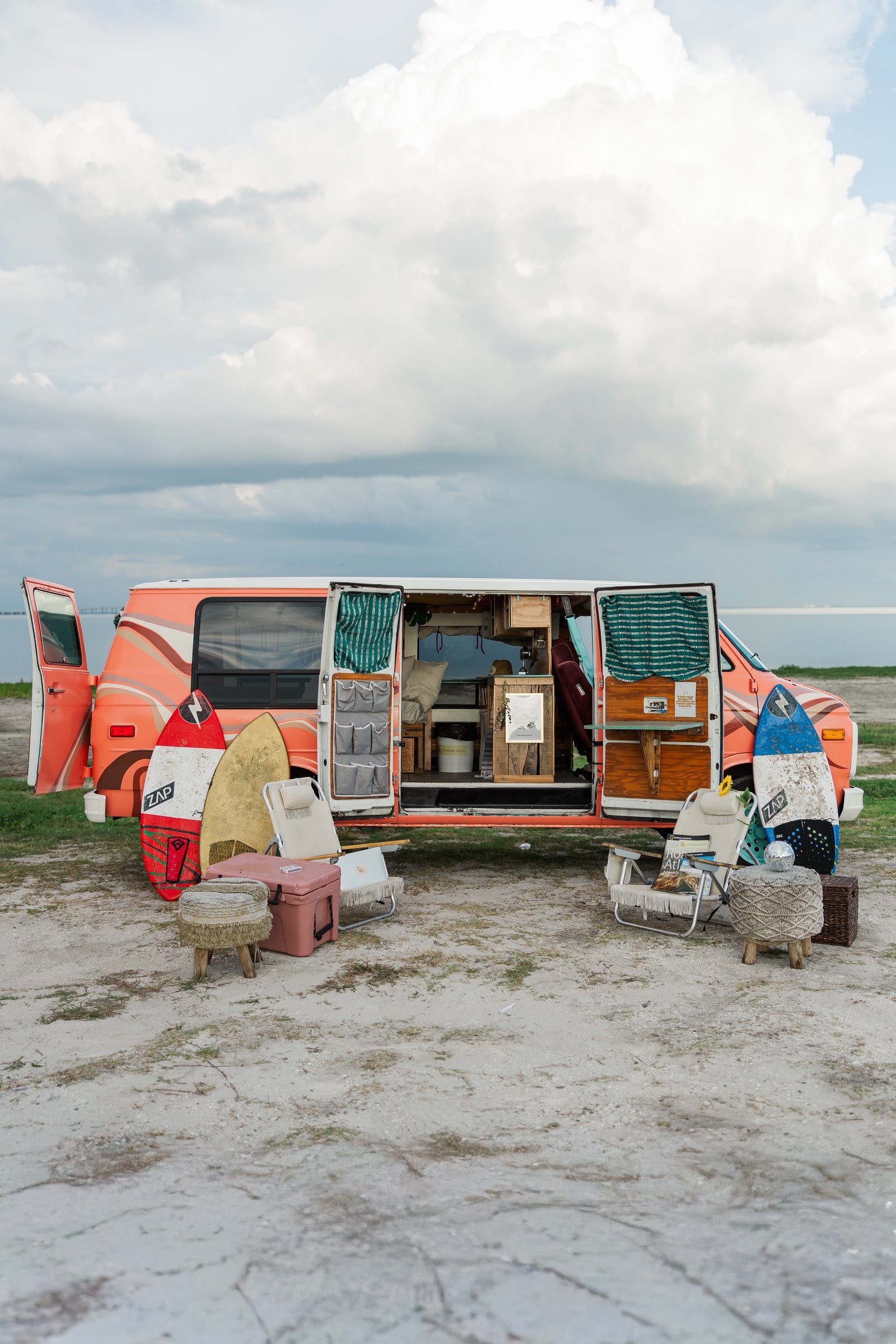 pink low-top camper van parked at the beach